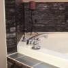 Steel looking decals applied to the horizontal tiles to compliment the dark rock around this tub